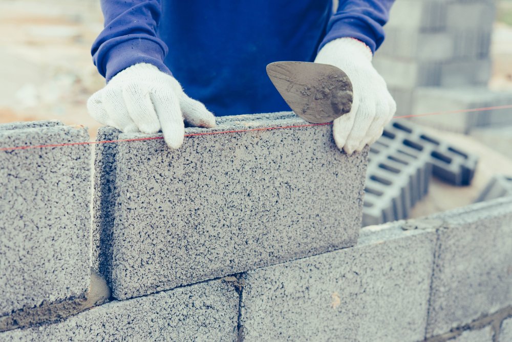 Worker building a wall with bricks